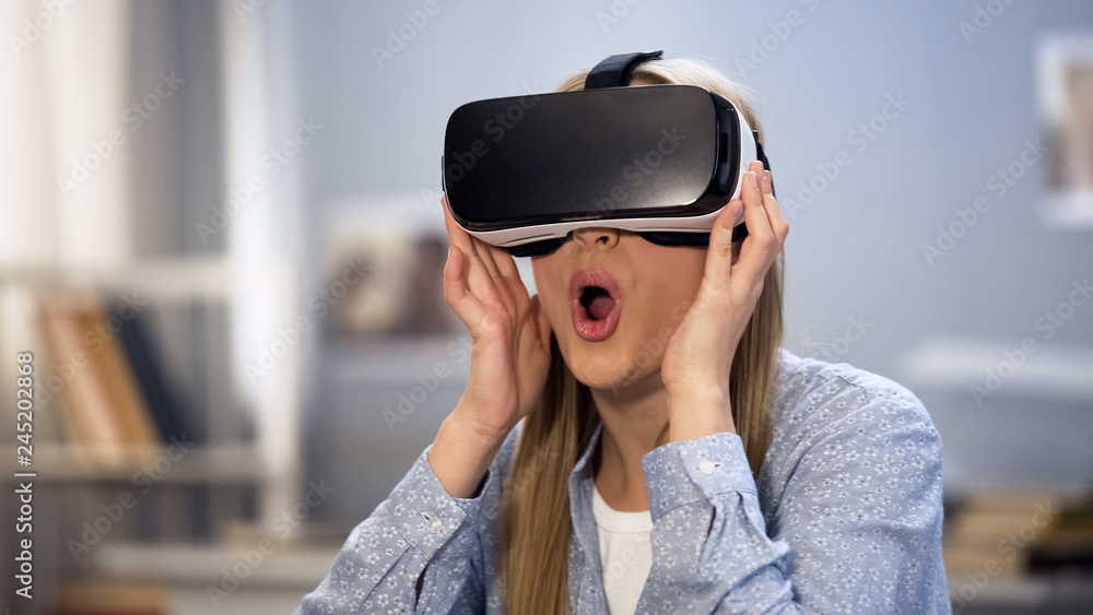Excited female gamer looking around in virtual reality glasses, innovation Excited female gamer looking around in virtual reality glasses, innovation