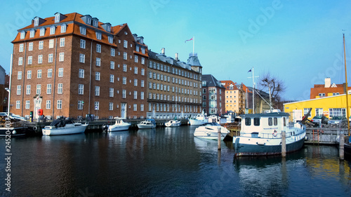 Ancient architecture with waving flag in Copenhagen harbor, tourism, resort