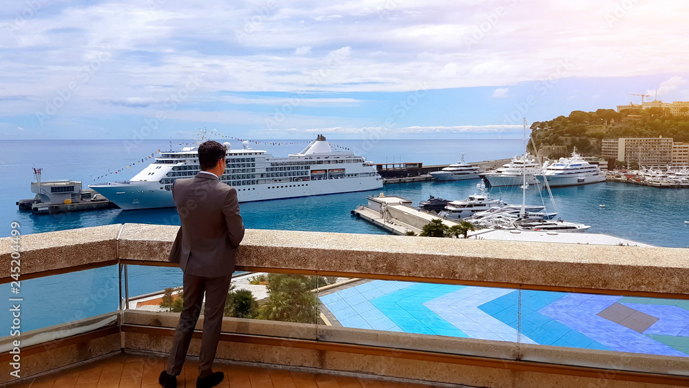 Serious businessman talking on phone, enjoying view of new yacht, private harbor Serious businessman talking on phone, enjoying view of new yacht, private harbor
