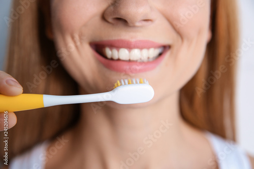 Smiling woman with toothbrush, closeup. Dental care