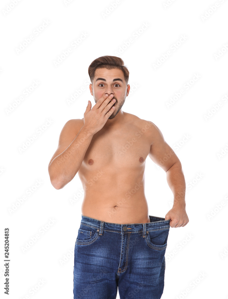 Fit man in oversized jeans on white background. Weight loss Fit man in oversized jeans on white background. Weight loss