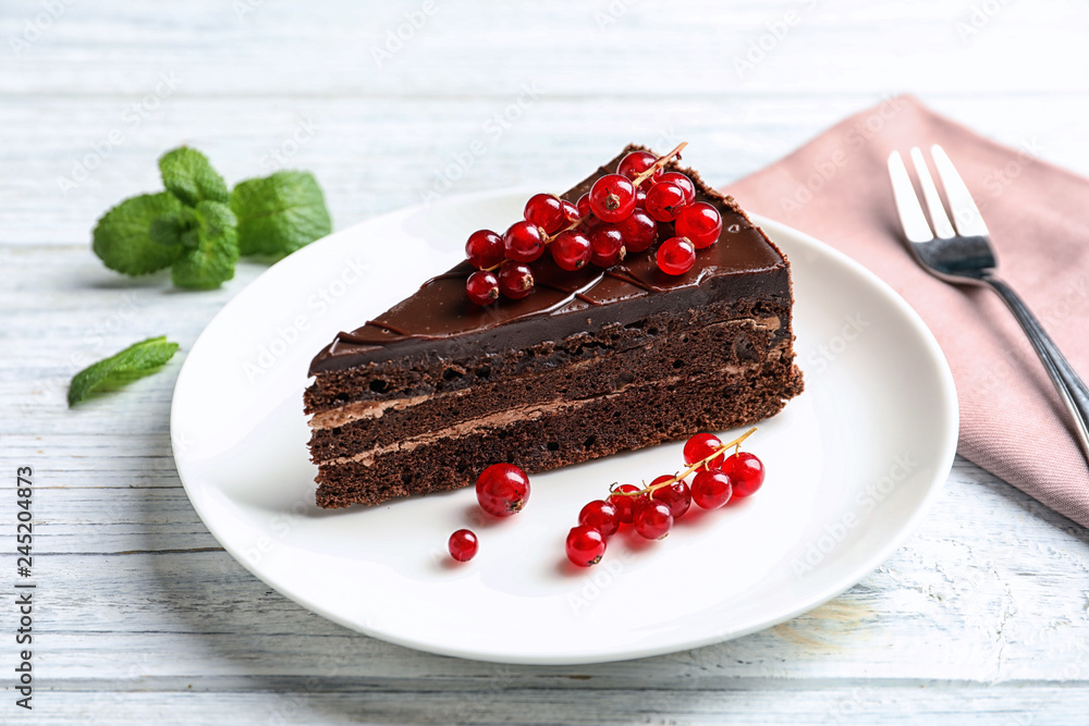 Plate with slice of chocolate cake and berries on table Plate with slice of chocolate cake and berries on table
