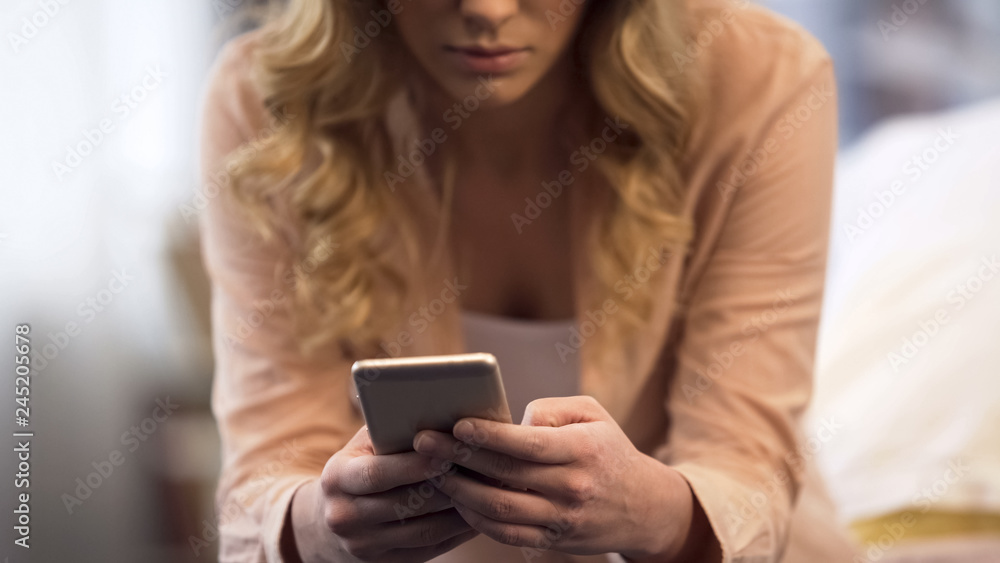 Young woman using smartphone, chatting with friends in social networks, closeup