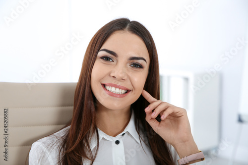 Portrait of young businesswoman laughing at workplace