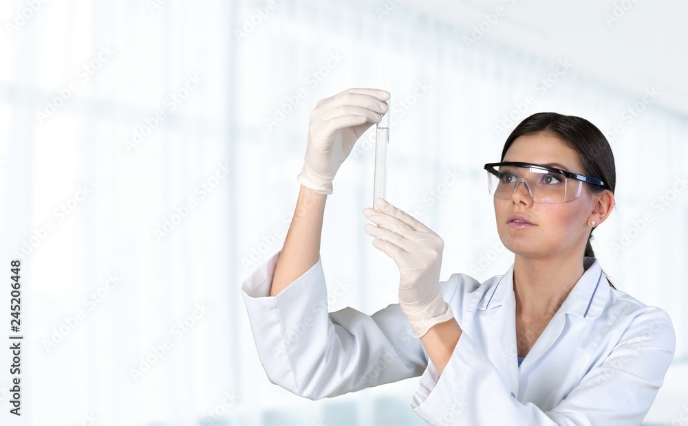 Young female scientist standing in her lab. Young female scientist standing in her lab.