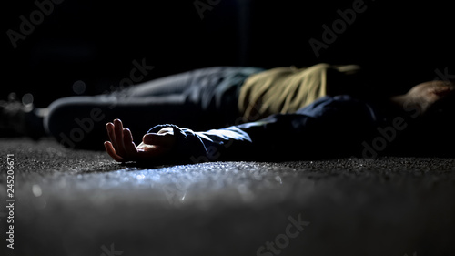 Body of woman lying on ground, contract killing, revenge or robbery, horror photo