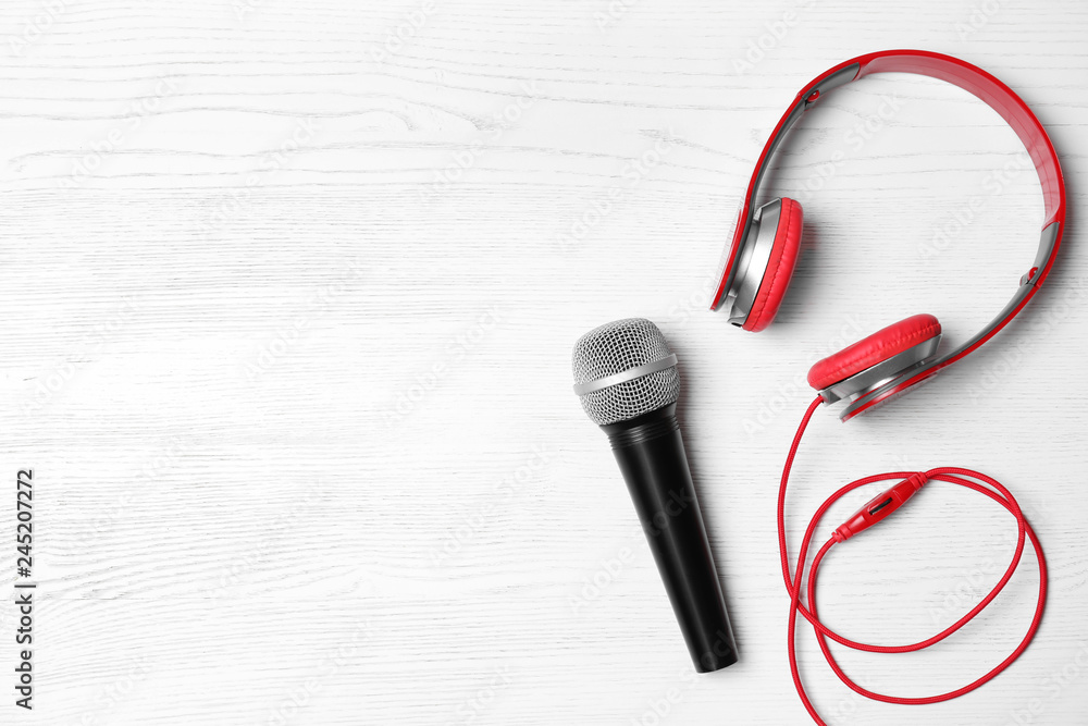 Headphones, microphone and space for text on white wooden background, top view Headphones, microphone and space for text on white wooden background, top view