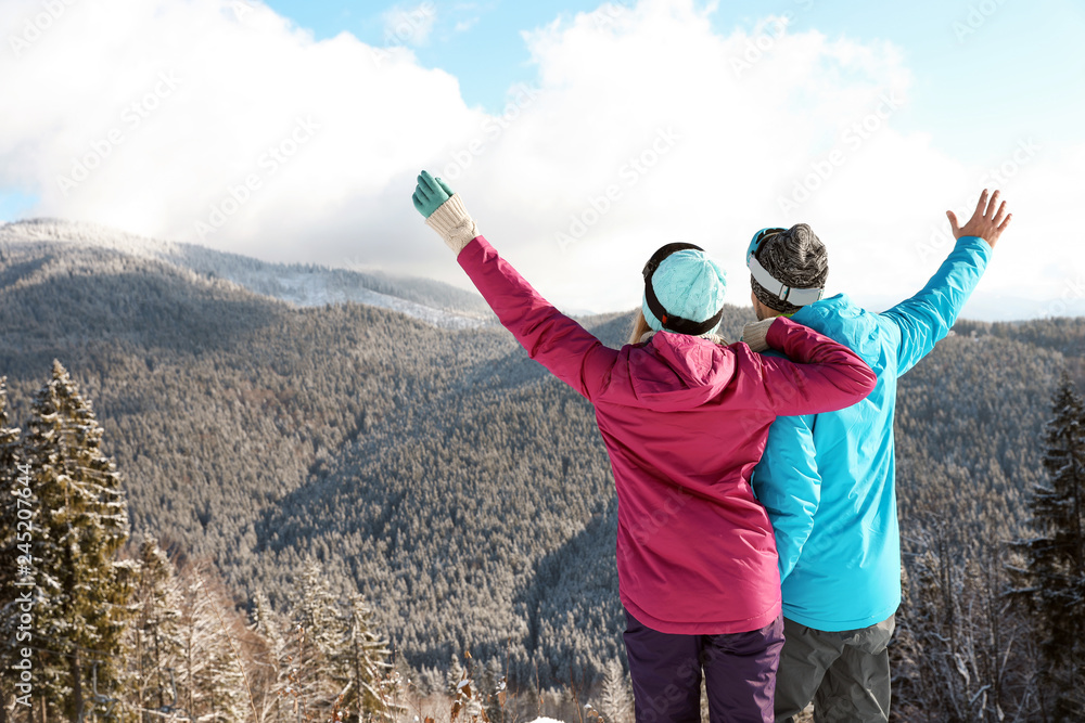 Couple spending winter vacation in mountains. Space for text