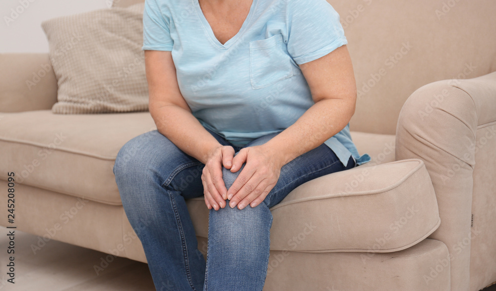 Senior woman suffering from knee pain at home, closeup Senior woman suffering from knee pain at home, closeup