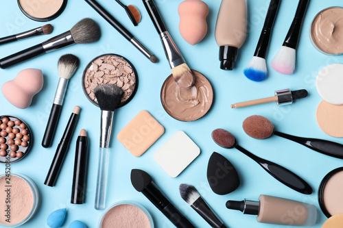 Flat lay composition with skin foundation, powder and beauty accessories on color background