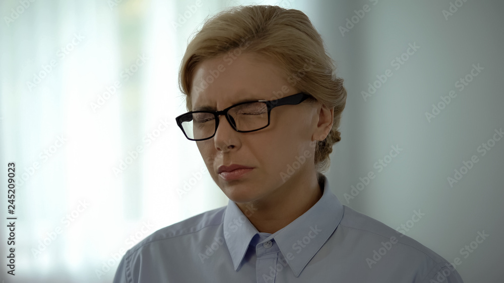 Business lady in eyeglasses feeling eye pain, long work in front of computer Business lady in eyeglasses feeling eye pain, long work in front of computer