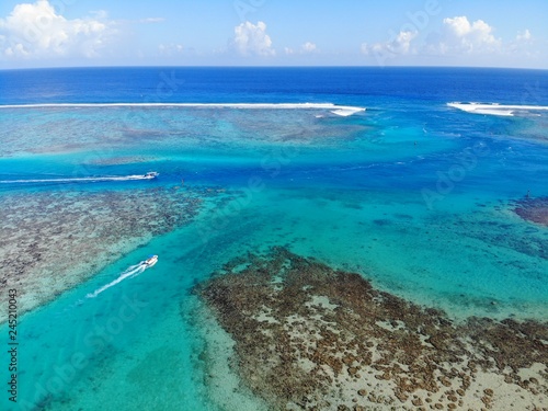 Fototapeta Naklejka Na Ścianę i Meble -  Aerial view of shades of blue and coral reefs over the Moorea lagoon in French Polynesia, South Pacific