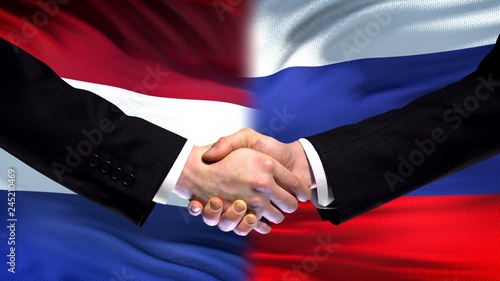Netherlands and Russia handshake, international friendship, flag background