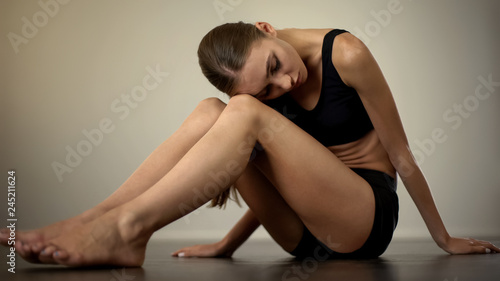 Depressed woman sitting on floor, suffering after painful break up, loneliness