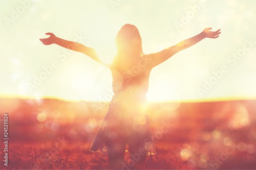 Young woman on field under sunset light