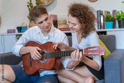 Teen couples are teasing each other during playing guitar in a romantic atmosphere.