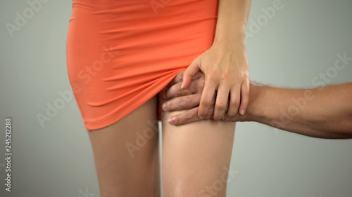 Mans hand stroking womans leg, weak to refuse lady suffering from sexual abuse photo