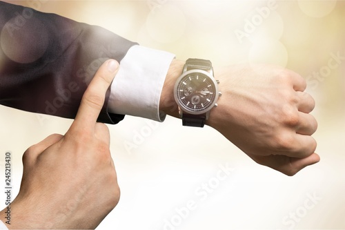 Businessman pointing at hand watch on white background, close-up