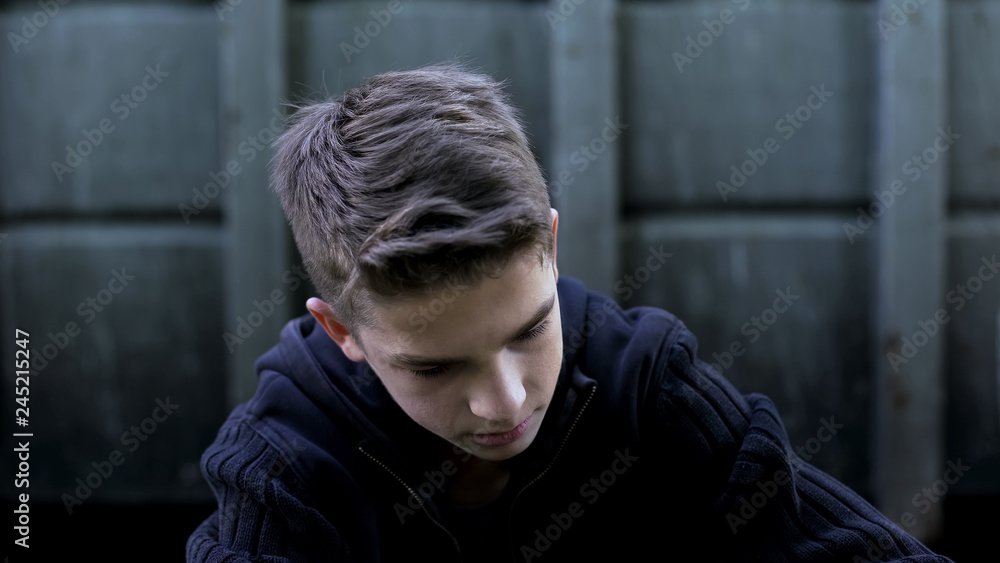 Fototapeta premium Depressed teenager boy feeling hopelessness, regretting wrong doings, sorrow