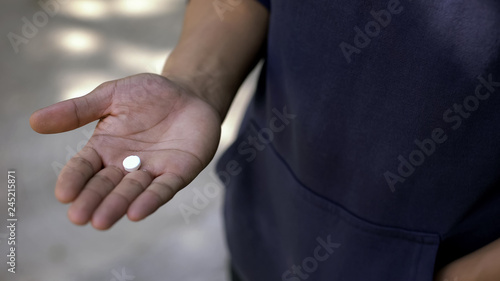 Guy trying pill with narcotic stuff, person looking for way to relax, addiction