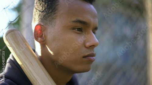 Photography Teen player holding baseball bat, waiting for game, street sport, mental warm-up