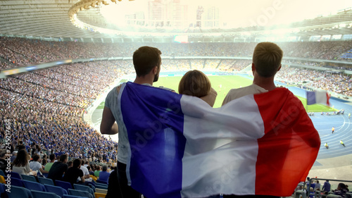Football fans with French flag jumping at stadium, cheering for national team photo