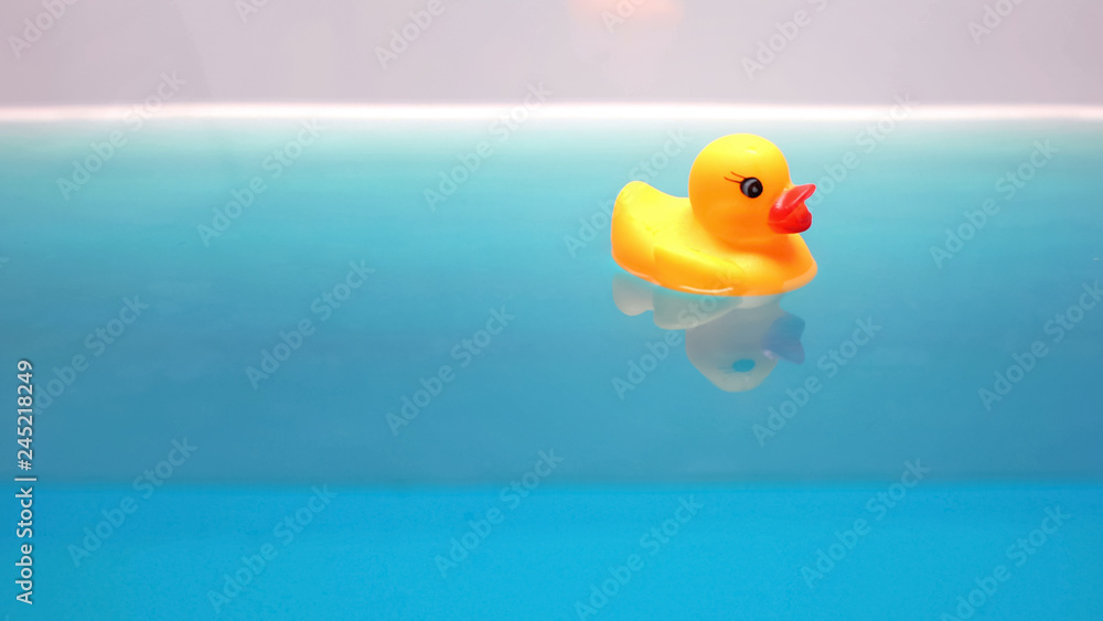 Yellow rubber duck floating in bath, relaxing time for children, macro shot Yellow rubber duck floating in bath, relaxing time for children, macro shot