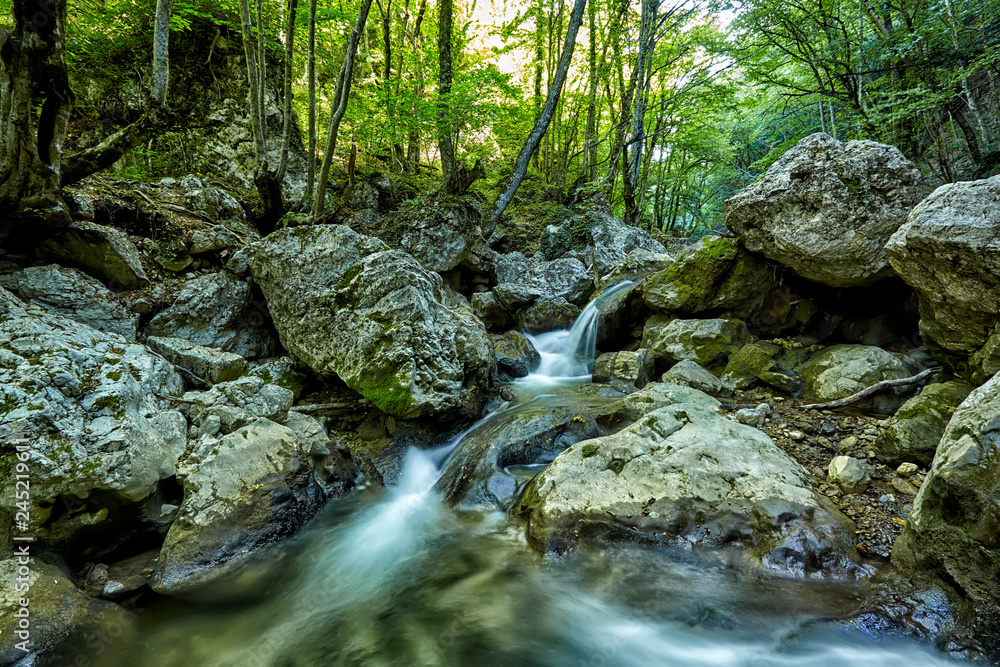 Beautiful waterfall in autumn forest in crimean mountains. Stones with moss in the water. Blurred water. Beautiful waterfall in autumn forest in crimean mountains. Stones with moss in the water. Blurred water.