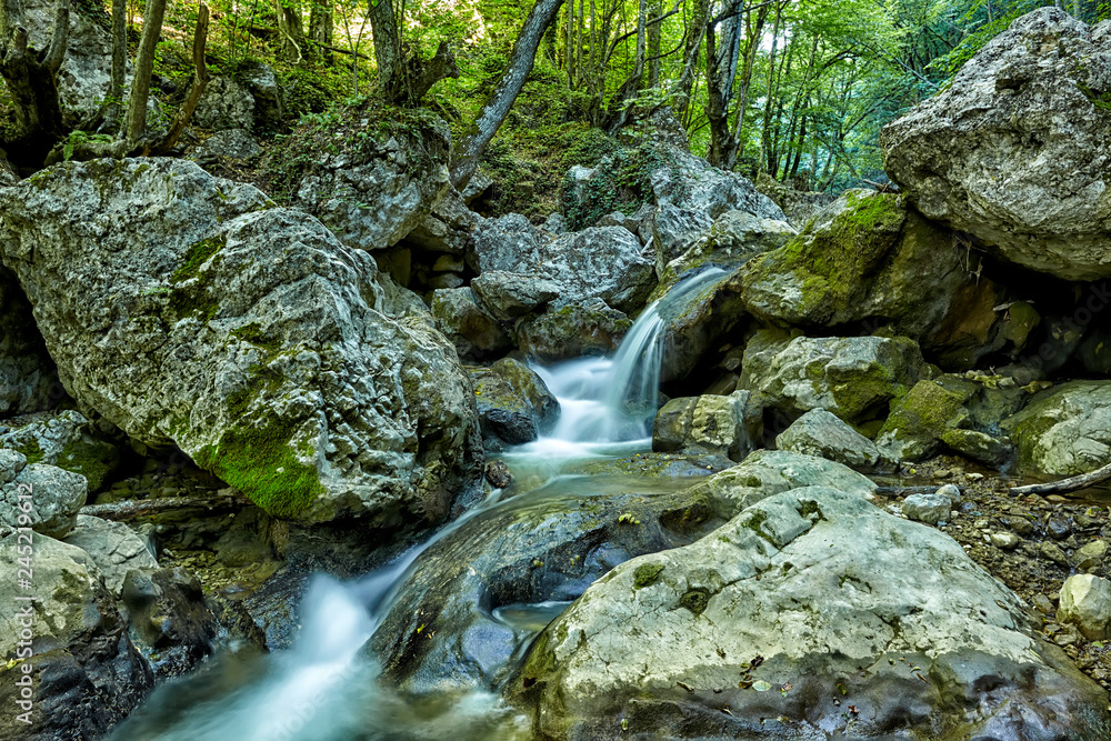 Beautiful waterfall in autumn forest in crimean mountains. Stones with moss in the water. Blurred water. Beautiful waterfall in autumn forest in crimean mountains. Stones with moss in the water. Blurred water.