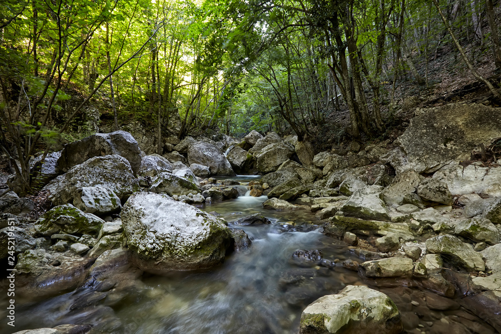 Beautiful waterfall in autumn forest in crimean mountains. Stones with moss in the water. Blurred water. Beautiful waterfall in autumn forest in crimean mountains. Stones with moss in the water. Blurred water.