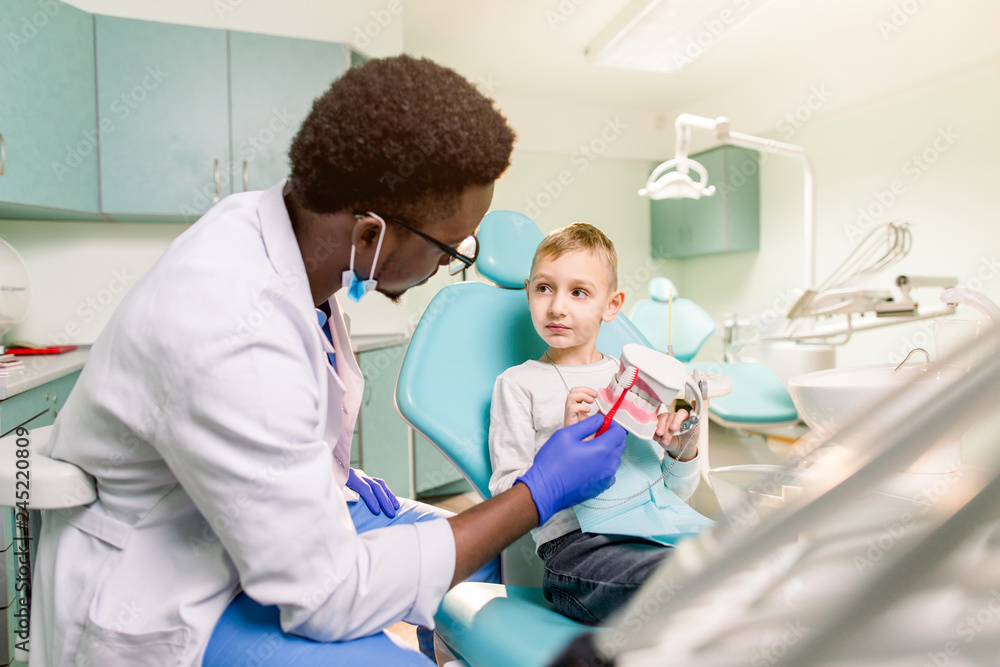 Obraz premium Dentist examines baby boy's teeth. Prophylaxis of caries, milk teeth, pediatrics