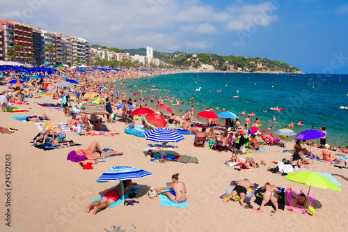 Obraz na płótnie Tourists on sandy sea beach in Lloret de Mar, Spain w salonie