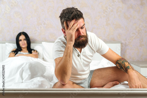 Unhappy married couple and sexual problems concept. Frustrated man and woman not talking feeling offended or stubborn. Couple mistake. Mid adult couple arguing in bedroom. photo