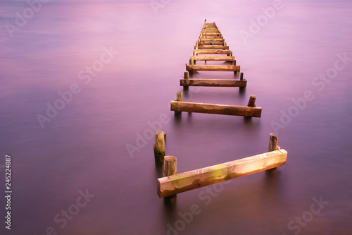 View of broken wooden pier in sea photo