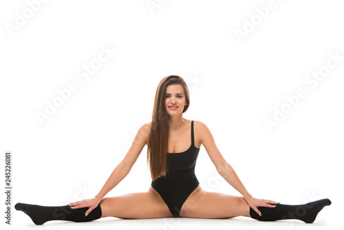 Young fitness woman wearing a sportswear doing stretching twine on the floor . Concept of healthy life