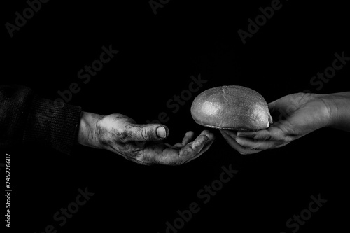 Woman giving Bread to poor man in need. Helping Hand Concept. Black and white photo