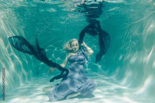 chubby sexy woman in grey evening long dress swimming underwater on her holidays and enjoy with relax