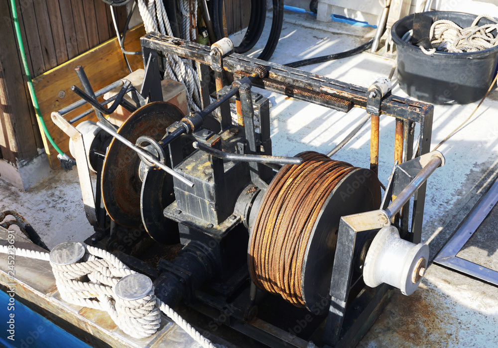 Old metal winch and ropes on the old fishing boat Stock Photo