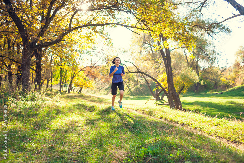 The girl runs through the autumn park.