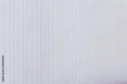 High resolution full frame background of pale and beige colored striped wallpaper. Selective focus, shallow depth of field.