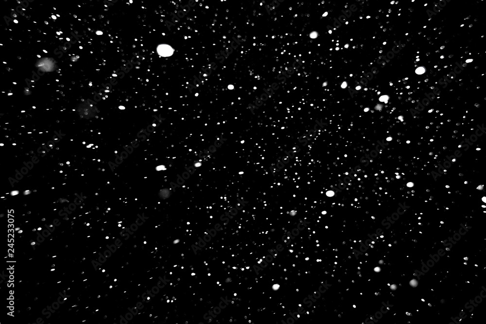 Obraz premium falling snow on a black background, snowfall at night, white spots on a black background