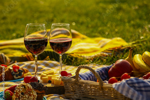 Picnic at the park on the grass: tablecloth, basket, healthy food and accessories
