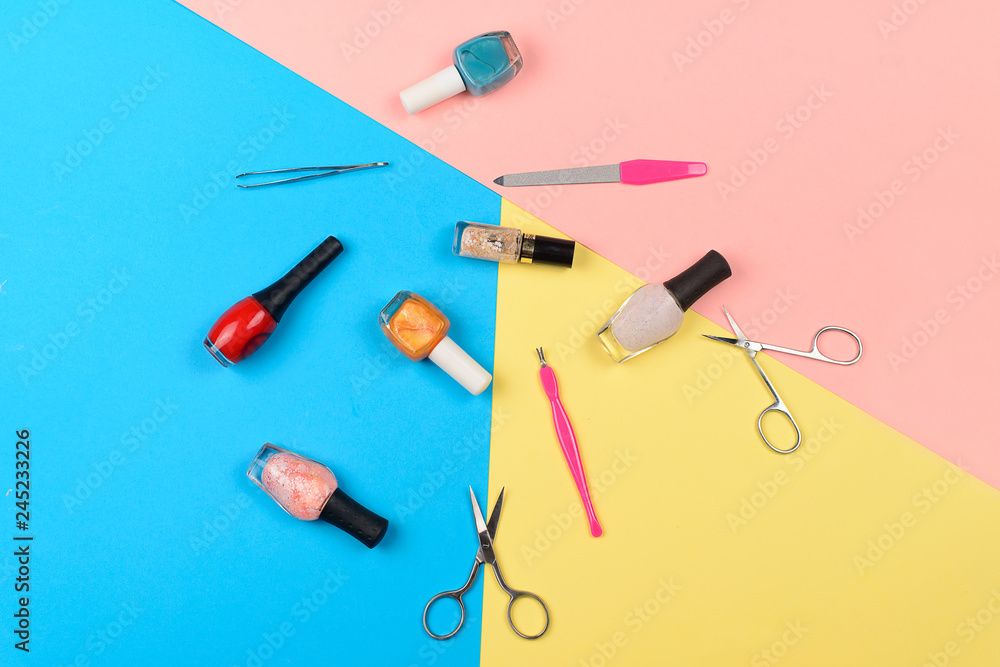 Nail polishes and tools for manicure on a colorful background Nail polishes and tools for manicure on a colorful background