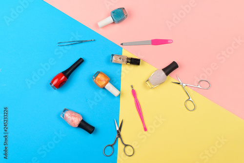  Nail polishes and tools for manicure on a colorful background