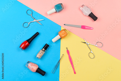  Nail polishes and tools for manicure on a colorful background