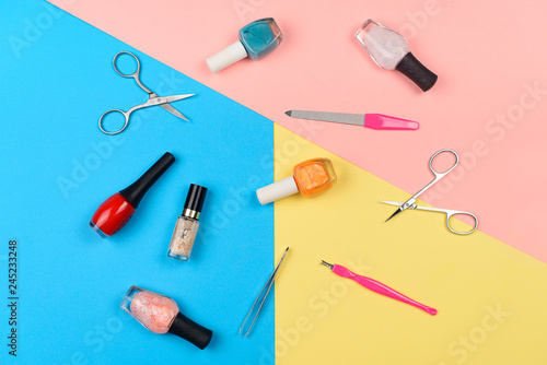  Nail polishes and tools for manicure on a colorful background