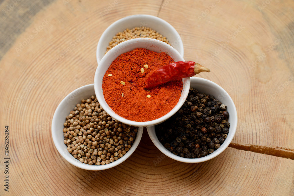 A set of spices on a wooden table. A set of spices on a wooden table.