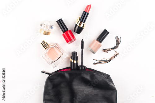 Cosmetics and makeup brushes on white background