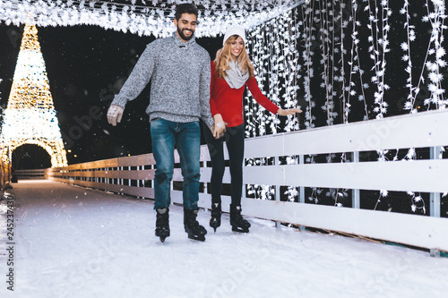 Happy romantic young couple enjoying together in ice skating.
