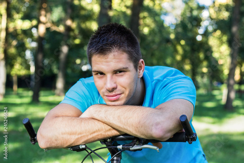 Handsome smiling man riding bike outdoors